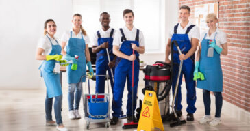 Portrait Of Happy Diverse Janitors In The Office With Cleaning Equipments