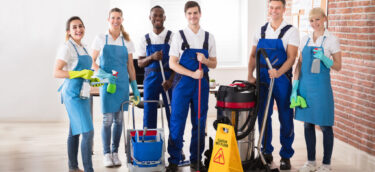 Portrait Of Happy Diverse Janitors In The Office With Cleaning Equipments